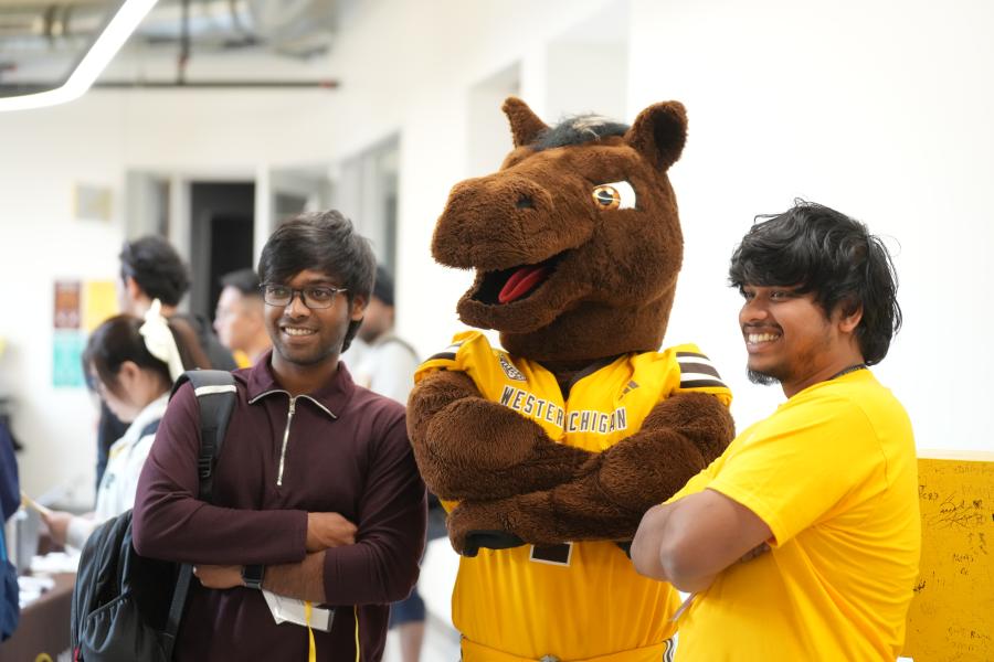 New international students pose with Buster Bronco at orientation.