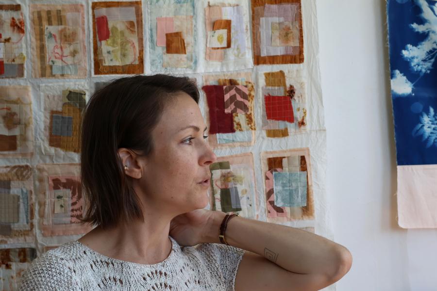 Kayla Powers, 2011 Art History alum, in her home studio in front of her textile art.
