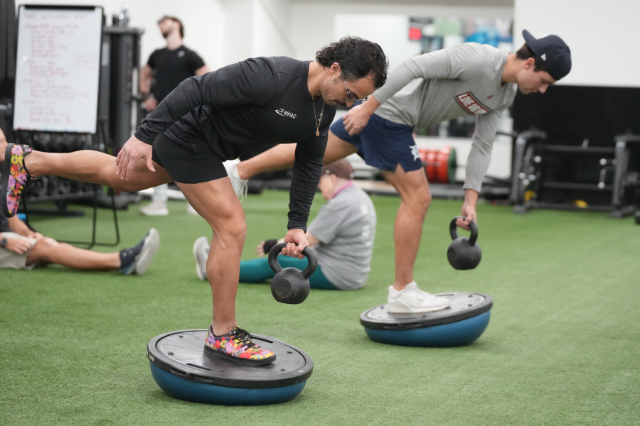 Dre lifting dumbbell with student 