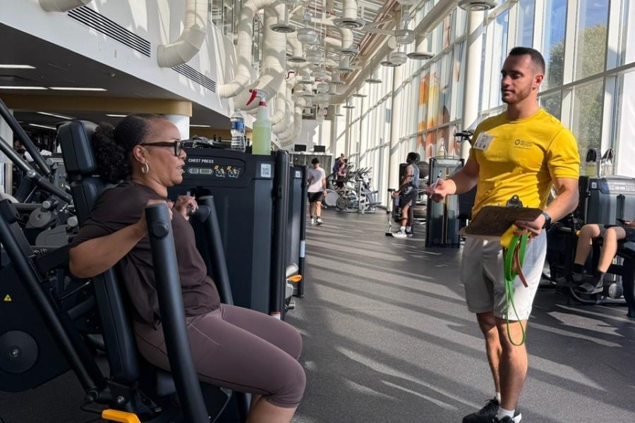 personal trainer in weight room with client