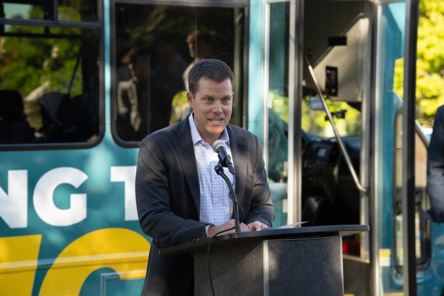 Dr. Doug Lepisto speaking in front of the new WMU to downtown Kalamazoo shuttle.