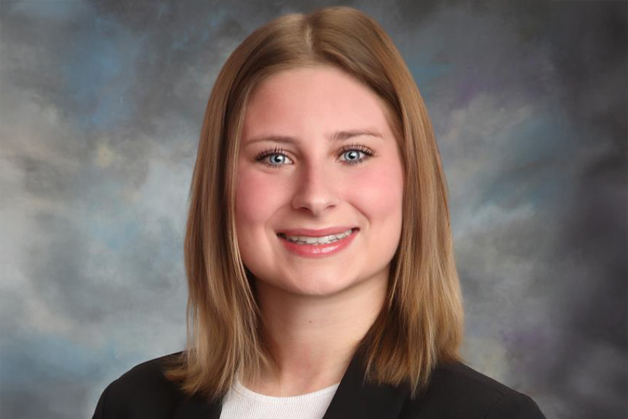 Headshot of Desiree Krawczyk in a white top and black blazer on a grey background
