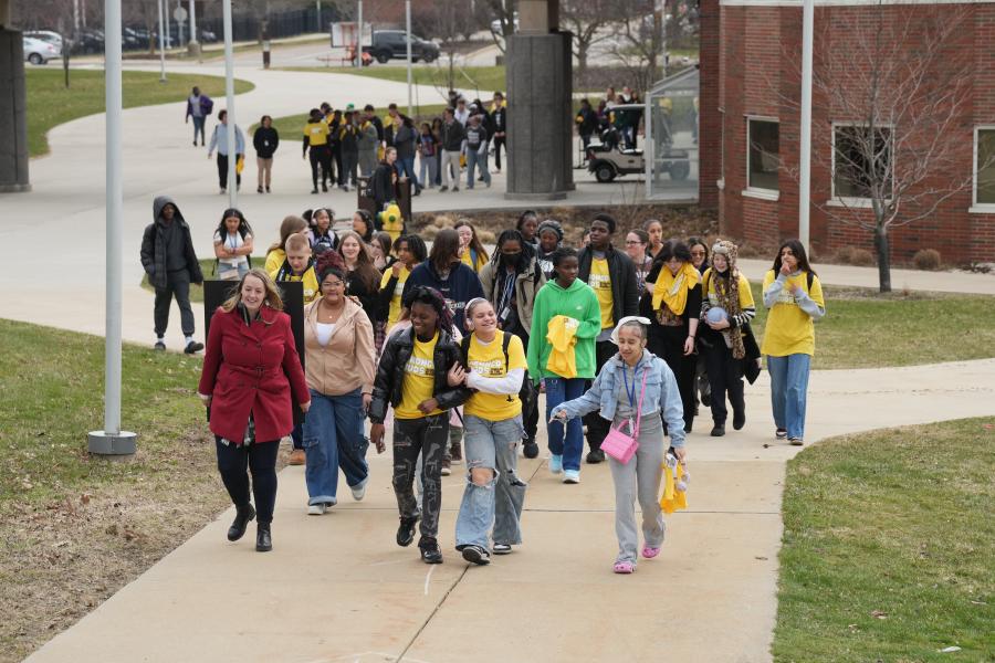 Students walk on a sidewalk on campus.