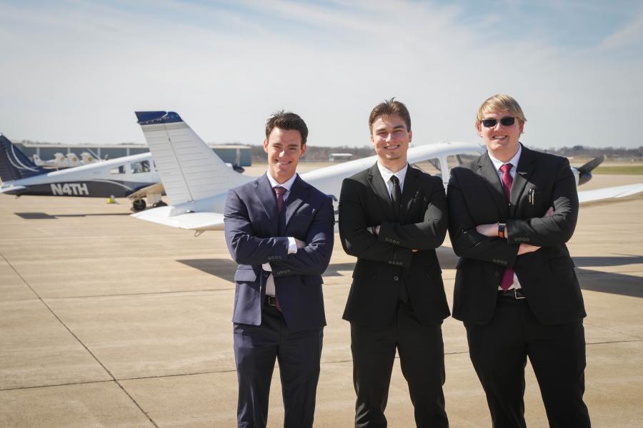students in front of plane