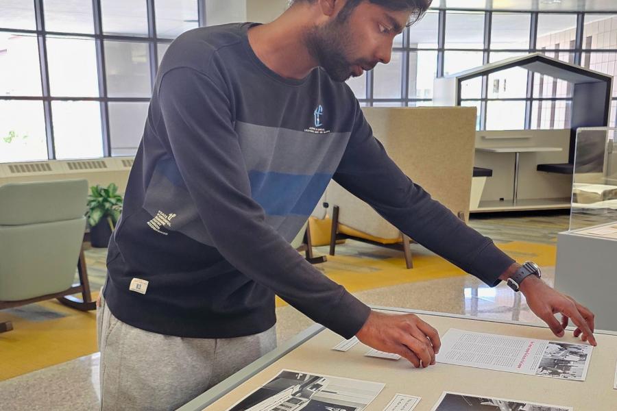 Western Michigan University student Benwin George working on exhibit case about the IBM 1620, WMU's first computer.