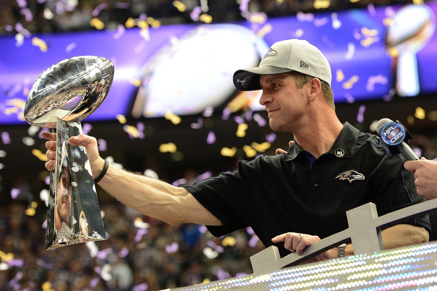 John Harbaugh holds the Lombardi Trophy.