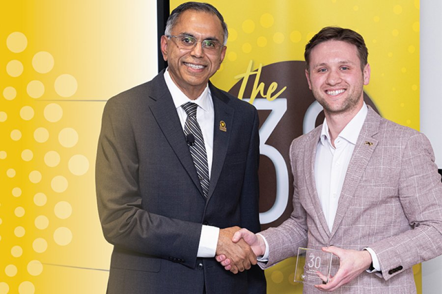 Alum receiving award