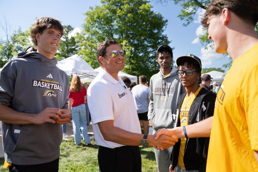 President Russ Kavalhuna shakes a student's hand.