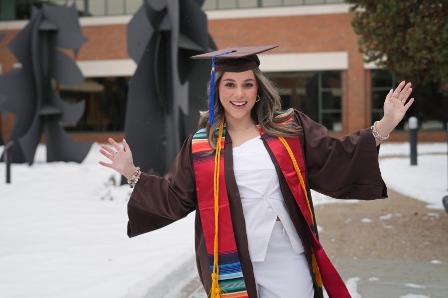 Daniela Padilla poses for a photo outside in her graduation regalia.