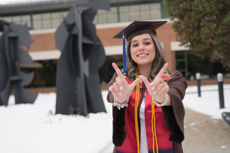 Daniela Padilla poses for a photo outside in her graduation regalia.