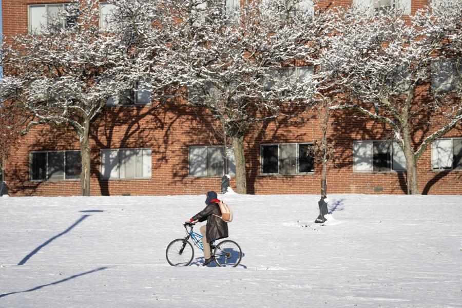 Student riding a bike in the snow