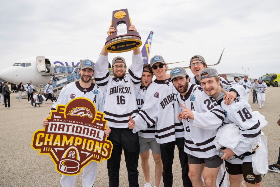 Hockey players hoist their national championship trophy in the air.