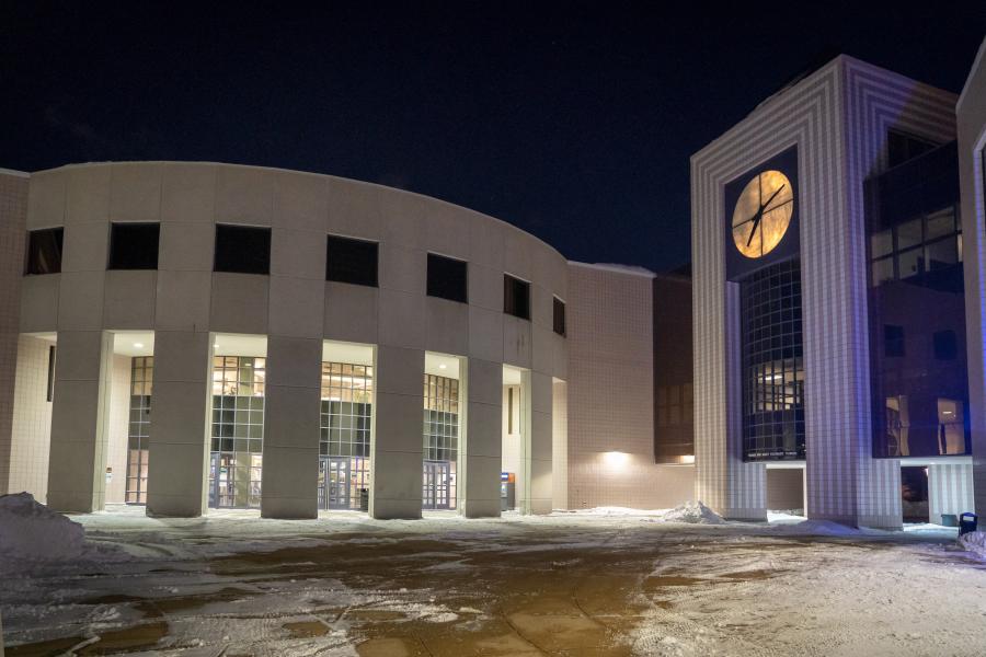 Outside of Waldo Library at night with snow on ground and inside lights on.