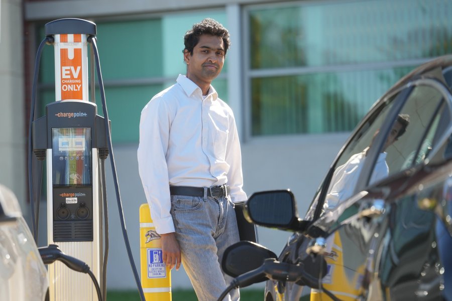 Dr. Shameek Bhattacharjee standing near electric vehicle charging station