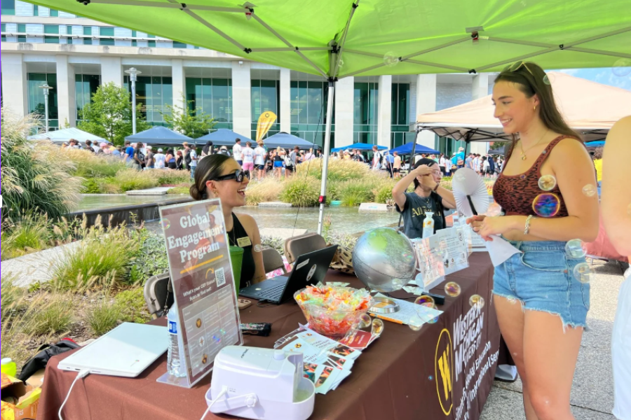 A GEP intern talks to students at an outside event. 