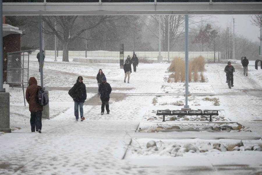 students walk through campus on a snowy day