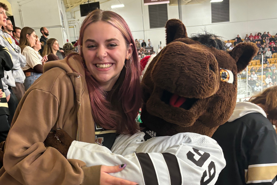 Alayna Sutherland with Buster Bronco at a hockey game in Lawson Ice Arena