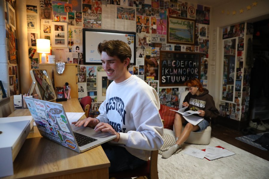 Student in residence hall typing on laptop