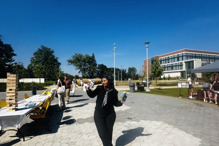 International student from India, Trivedi, stands for photo while making a bubbles. 
