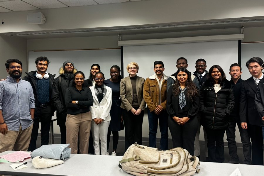 International student from India, Trivedi, stands for photo with WMU students.