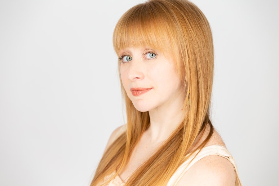 Headshot of Jessica Tomlinson, blonde with bangs looking into camera.