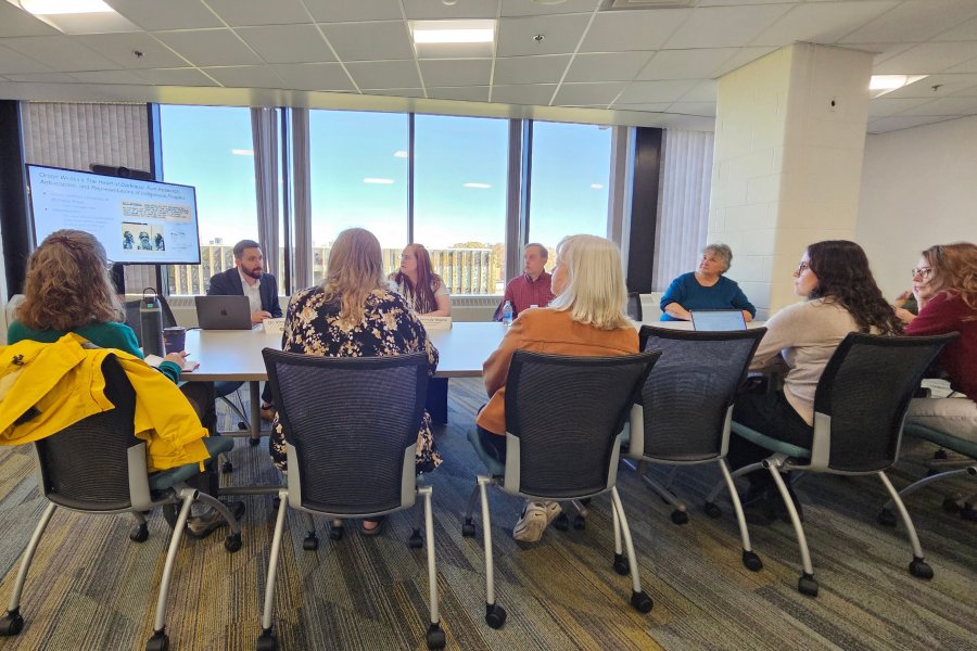 Open accessl panel discussion attendees sitting around at table at Waldo Library.