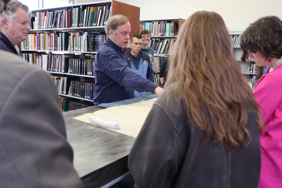 Dr. Robert Berkhofer (center) notes details in the facsimile of a papal investigations into allegations against the Knights Templar at Zhang Legacy Collections Center.