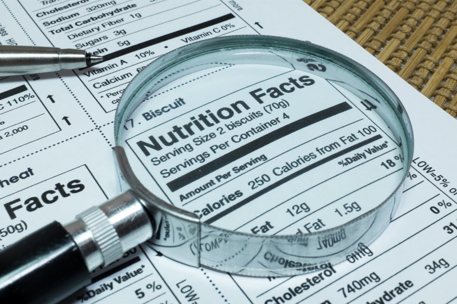 A magnifying glass hovering over a Nutrition Facts label enlarging the area where it says Calories