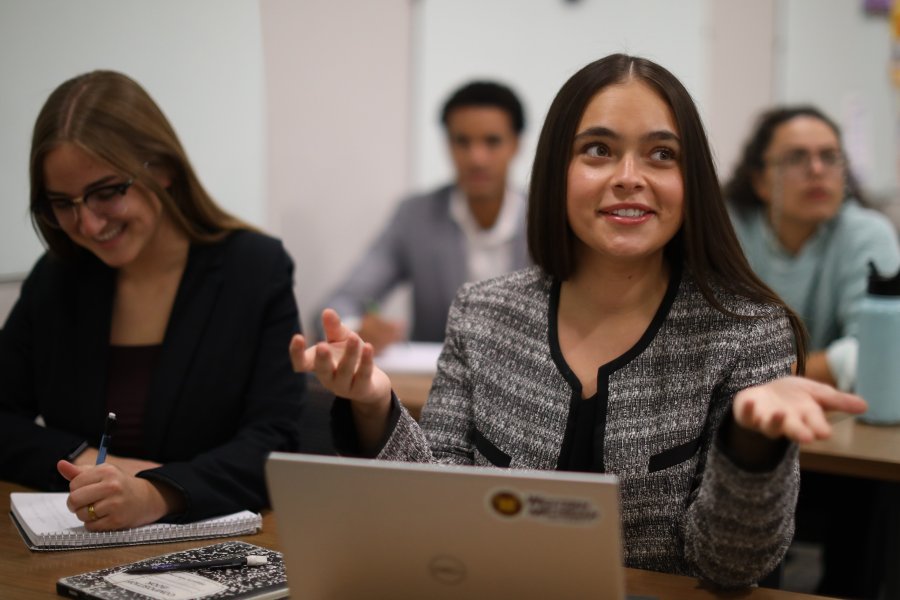 Students seated in a classroom with a laptop.