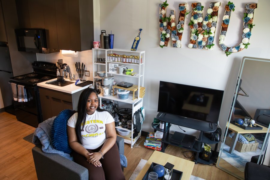 A WMU student sits in a decorated Arcadia Flats apartment living room.