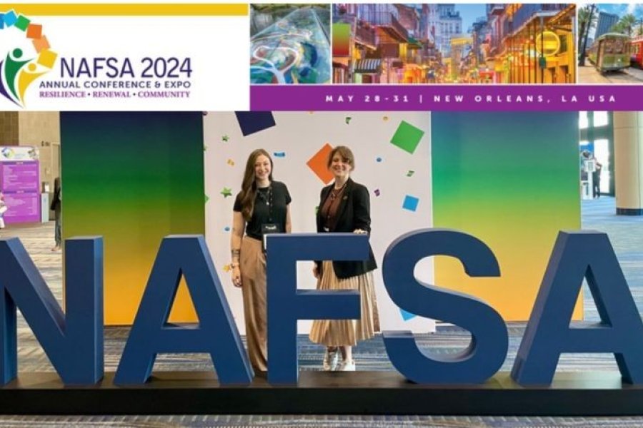 Two staff members of the Global Engagement Program stand next to giant letters, a sign spelling N-A-F-S-A.