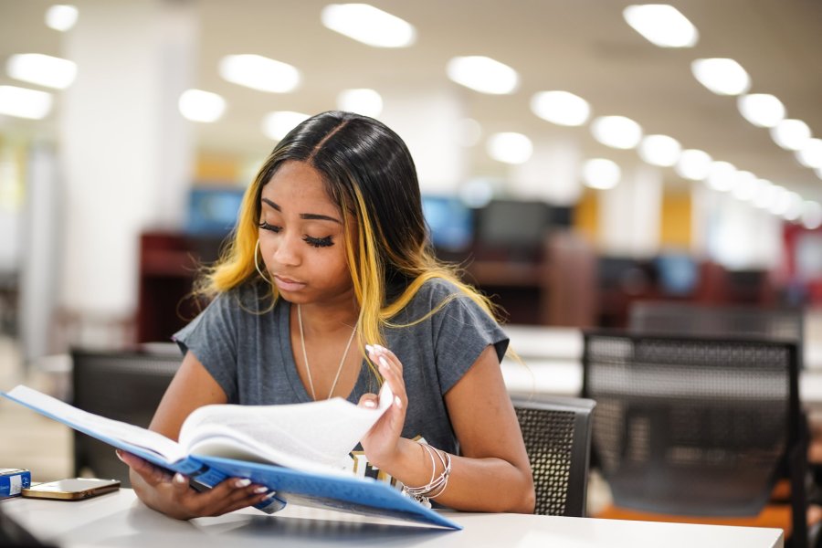 Student looking at book in Waldo Library.