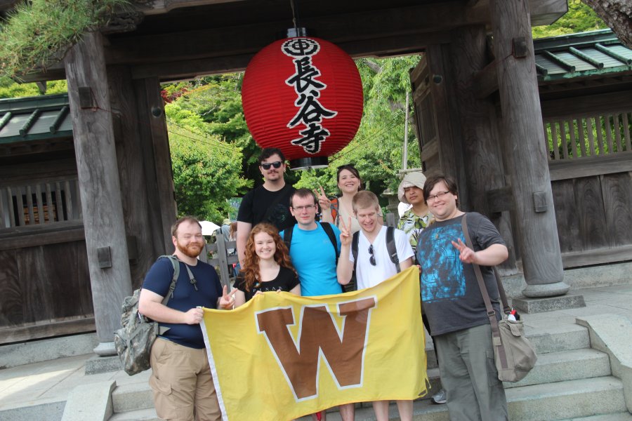 Study abroad students holding WMU flag in Japan