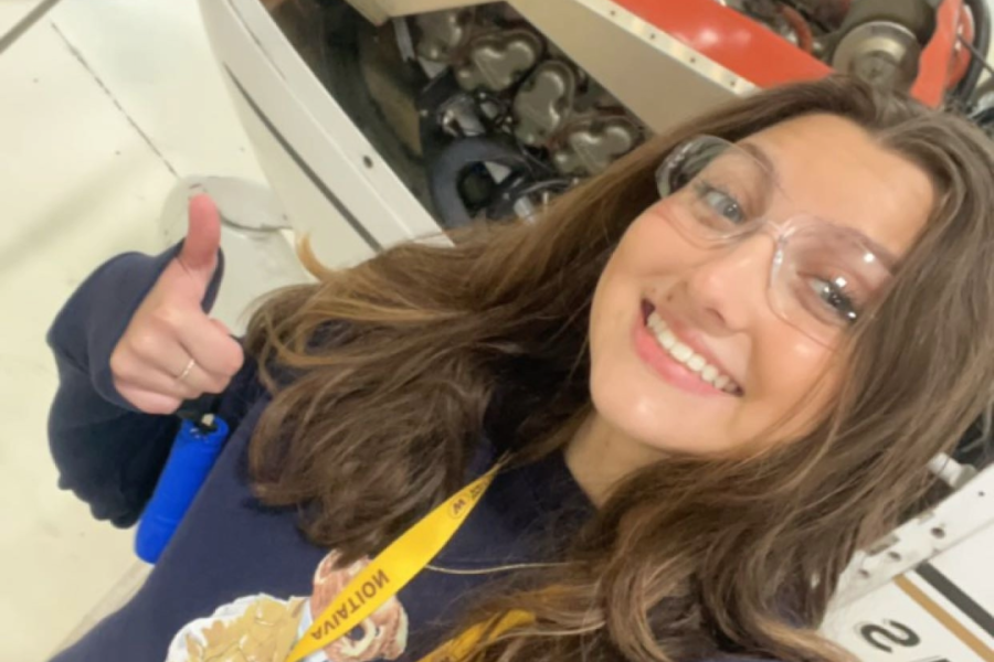 Student in front of plane engine.