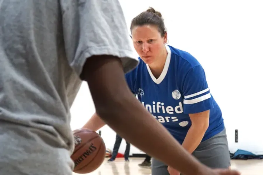 Merrill DeRose playing basketball with student at Salem High