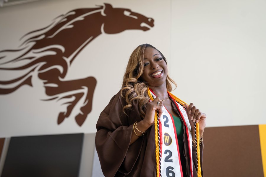 A'maree Waddell stands under a horse painted on the wall.