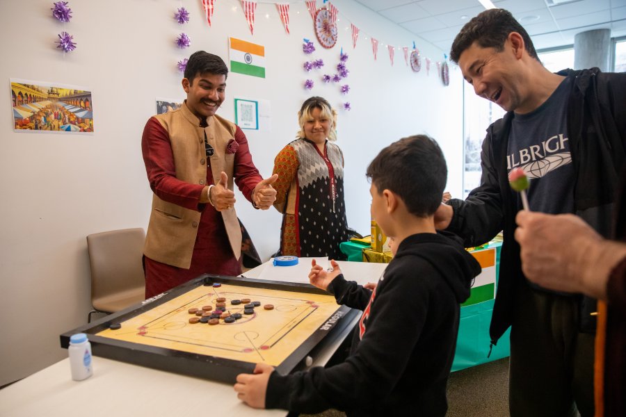 A student in the Indian Student Association interacts with a family at International Bazaar 2026.