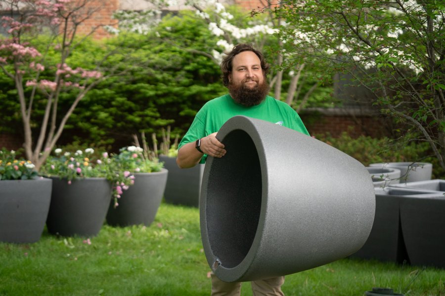 Landscape Services has received a grant from the Office for Sustainability for purchasing dozens of self-watering planters. Groundkeeper David Prellwitz carries one of the self-watering planters.