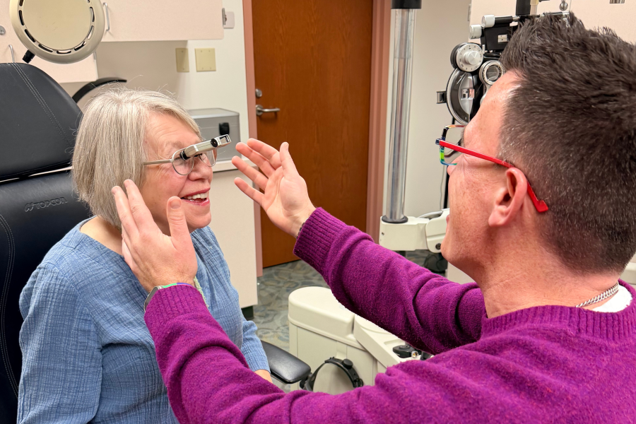 Dr. Johnson examines a low vision patient in the optometry exam room in the Unified Clinics.