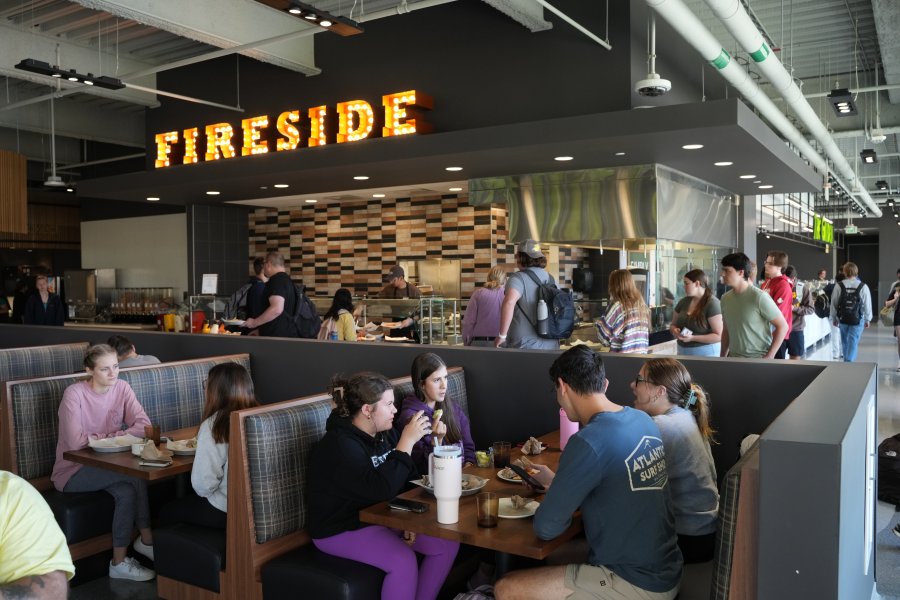 Students line up for food and eat together in large booths in the Student Center Dining facility.