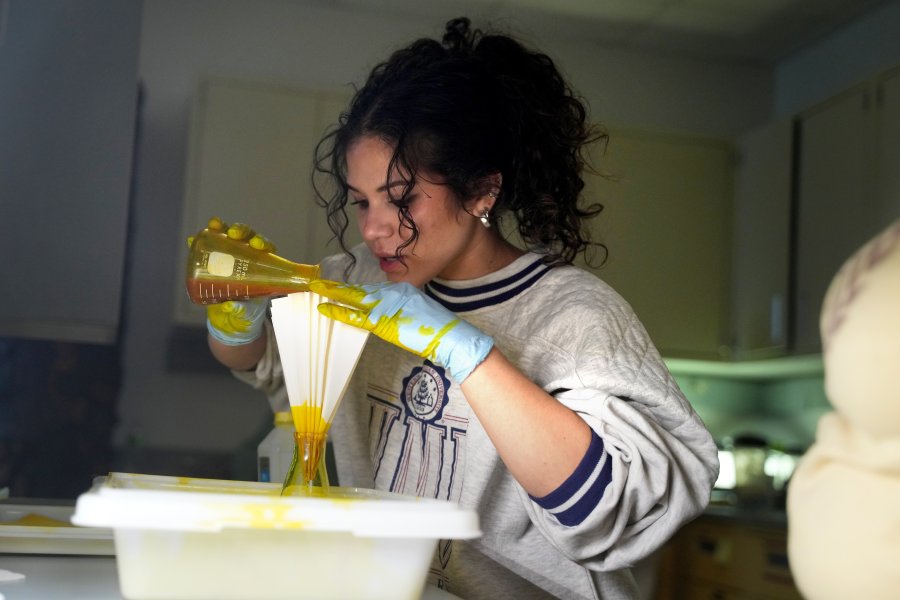 A student pours liquid from a beaker in a science lab.