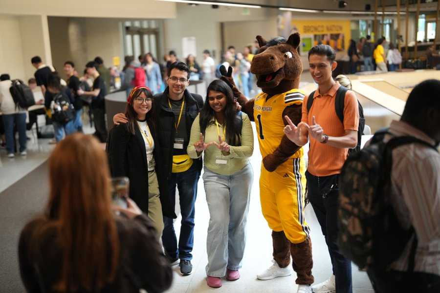 Students hold W hands with Buster Bronco at International Student Orientation 2026. They pose with Buster Bronco.