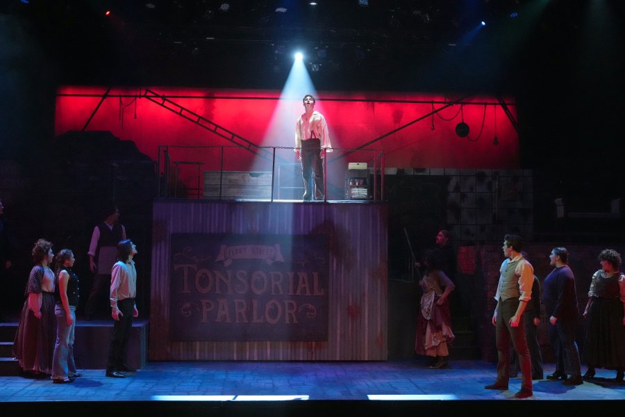 Jack Austin stands under the spotlight on stage while playing Sweeney Todd in the theatre production of the same name.