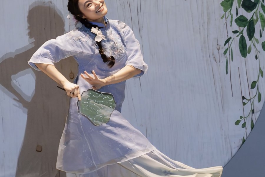 Woman performs Asian cultural dance on stage at Spring Gala.