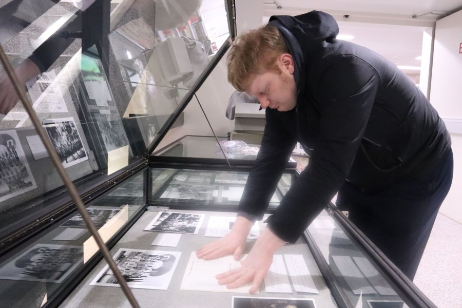 Western Michigan University student Graham Alburtus working on exhibit case about Bronco's Best Season: 1975-1976 Drive to Glory.