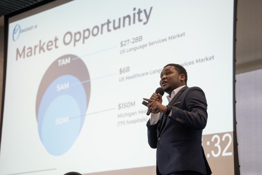 Samuel Marseille presents a powerpoint slide during a pitch competition.