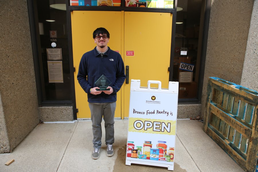 Mario Antonio Valenzuela holds his Undergraduate Student Employee of the Year Award outside the Bronco Food Pantry.
