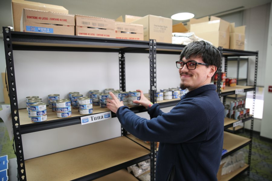 Mario Antonio Valenzula stocks food on shelves for Montgomery Essential Needs.