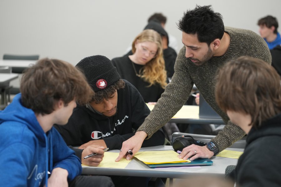 A WMU professor speaks to students at a table.