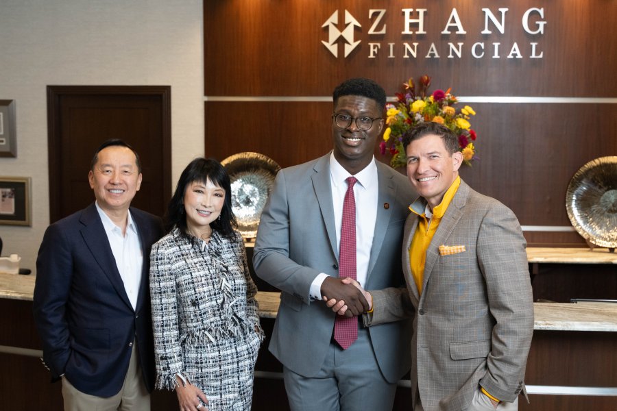 Charles Zhang, Lynn Chen-Zhang, Mo Tall and President Russ Kavalhuna stand in the lobby of Zhang Financial.